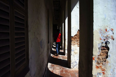 Rear view of woman walking in corridor of building