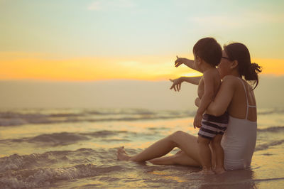 Mother and son gesturing at beach