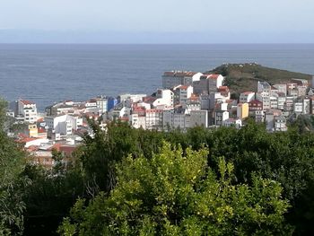 High angle view of town by sea against clear sky