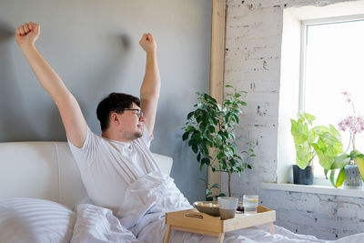 Side view of young woman doing yoga at home