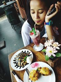 High angle view of woman holding ice cream on table