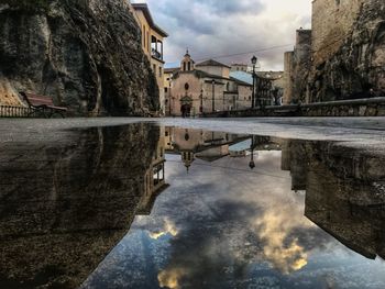 Reflection of buildings in puddle on lake