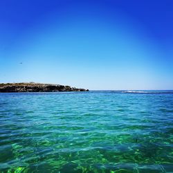 Scenic view of sea against clear blue sky