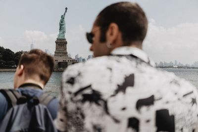 Rear view of man against statue of liberty