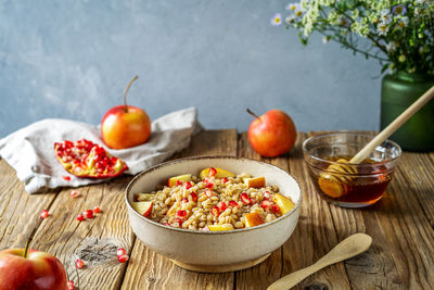 Sweet homemade barley porridge with pomegranate seeds, apples and honey. rosh hashanah celebration