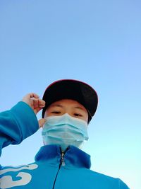 Portrait of boy wearing hat against clear blue sky