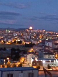 Illuminated cityscape against sky at night