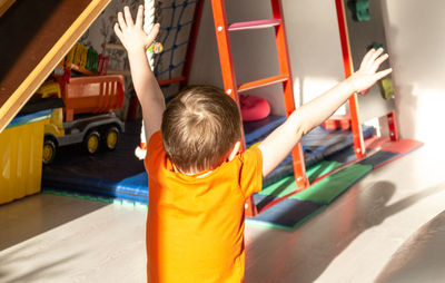 Rear view of boy playing at playground