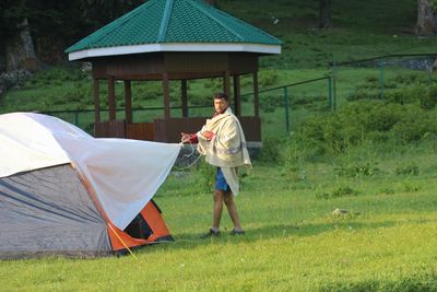 Full length of man standing in tent on field