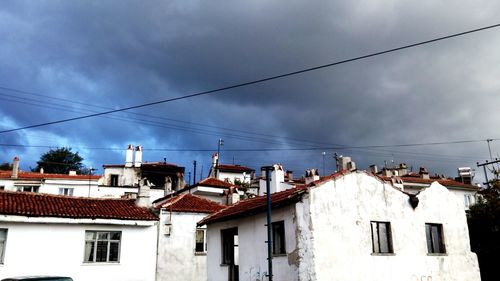 Low angle view of houses against cloudy sky