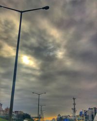 Low angle view of power lines against cloudy sky