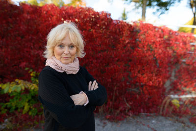 Portrait of smiling woman standing by plants during autumn