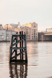 Buildings by river against clear sky