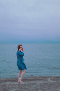 Full length of young woman standing on beach