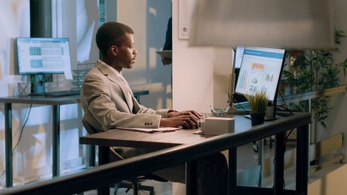 Side view of man using digital tablet in office