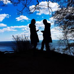 Silhouette of tree against blue sky