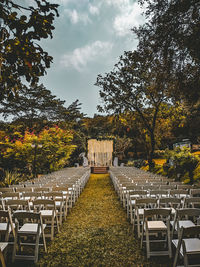 Empty chairs and tables against trees