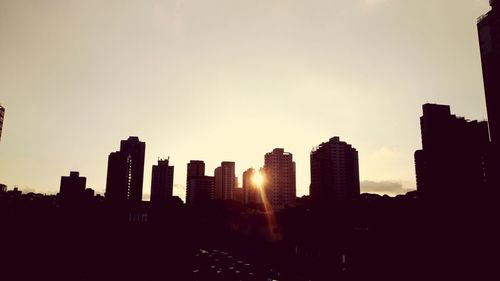 Silhouette buildings against sky during sunset