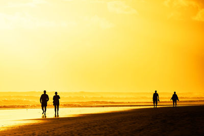 Tourists visiting beach against sky