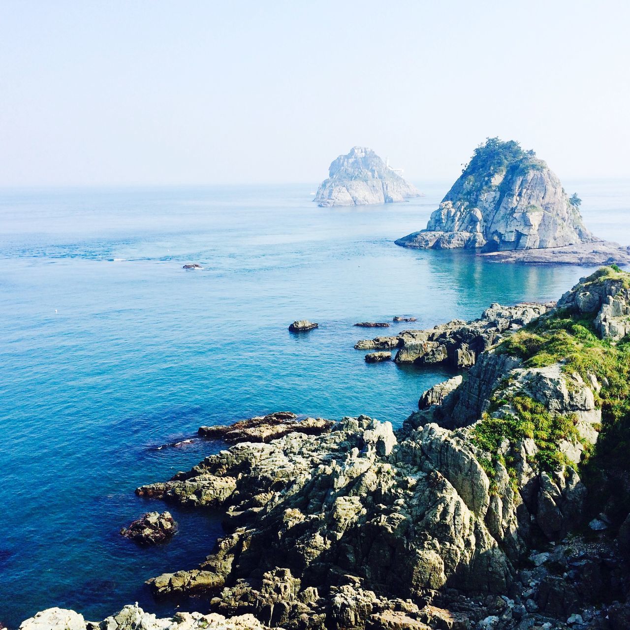 water, sea, tranquil scene, tranquility, scenics, beauty in nature, rock - object, horizon over water, mountain, rock formation, nature, clear sky, cliff, blue, rock, idyllic, sky, day, remote, non-urban scene