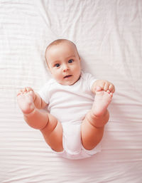 High angle view of baby lying on bed