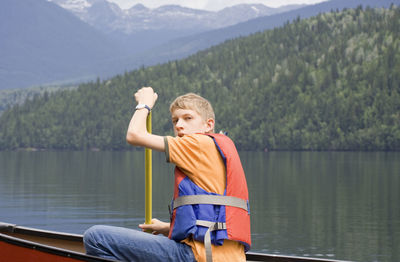 Portrait of teenage boy canoeing on lake