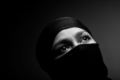 Portrait of woman against black background