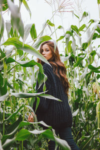 Portrait of woman standing against plants