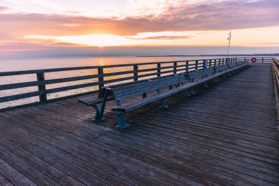 Pier over sea against sky during sunset