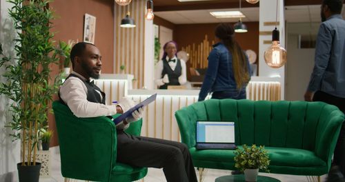 Side view of man using laptop while sitting in office