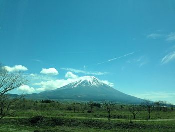 Scenic view of snowcapped mountains against blue sky