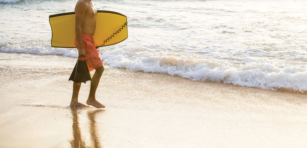 Rear view of woman walking on beach