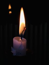 Close-up of lit candle in darkroom