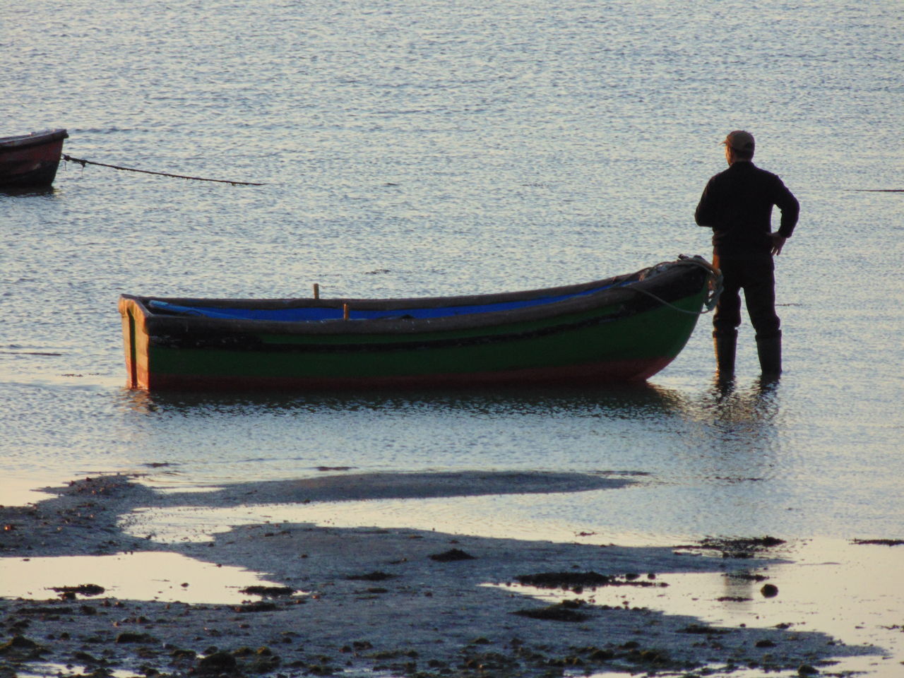 REAR VIEW OF MAN STANDING AT BEACH