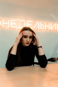 Portrait of young woman with text on wall