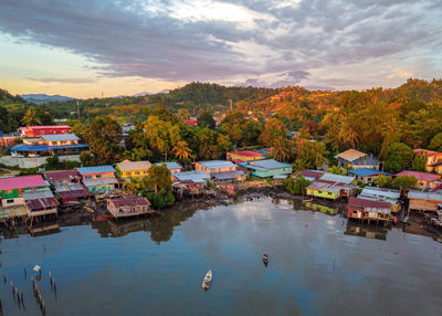 High angle view of houses by lake against sky