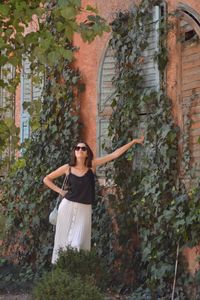 Full length of woman standing by tree