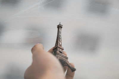 Cropped hand holding replica eiffel tower