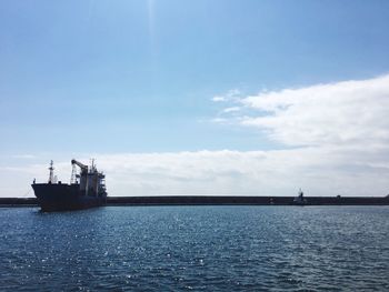 Ship sailing on sea against sky