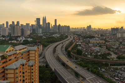 High angle view of bridges in city at sunset