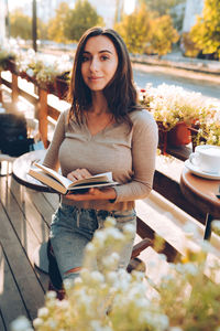 Portrait of beautiful woman reading a book while relaxing in the cafe.