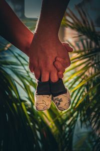 Cropped hands of couple holding baby booties