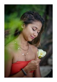 Portrait of woman with pink flower