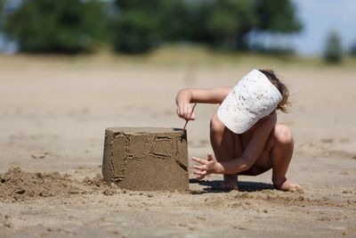 Full length of girl making sand castle at beach