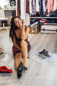 Portrait of smiling young woman sitting on floor