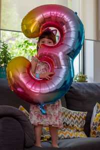 Rear view of girl holding balloons