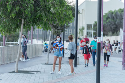 People walking on footpath in city