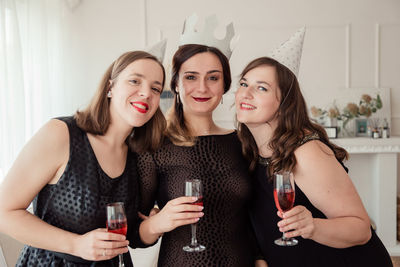 Portrait of smiling woman with friends celebrating at home