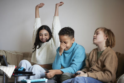 Children playing video games at home and celebrating