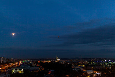 High angle view of illuminated city against sky at dusk